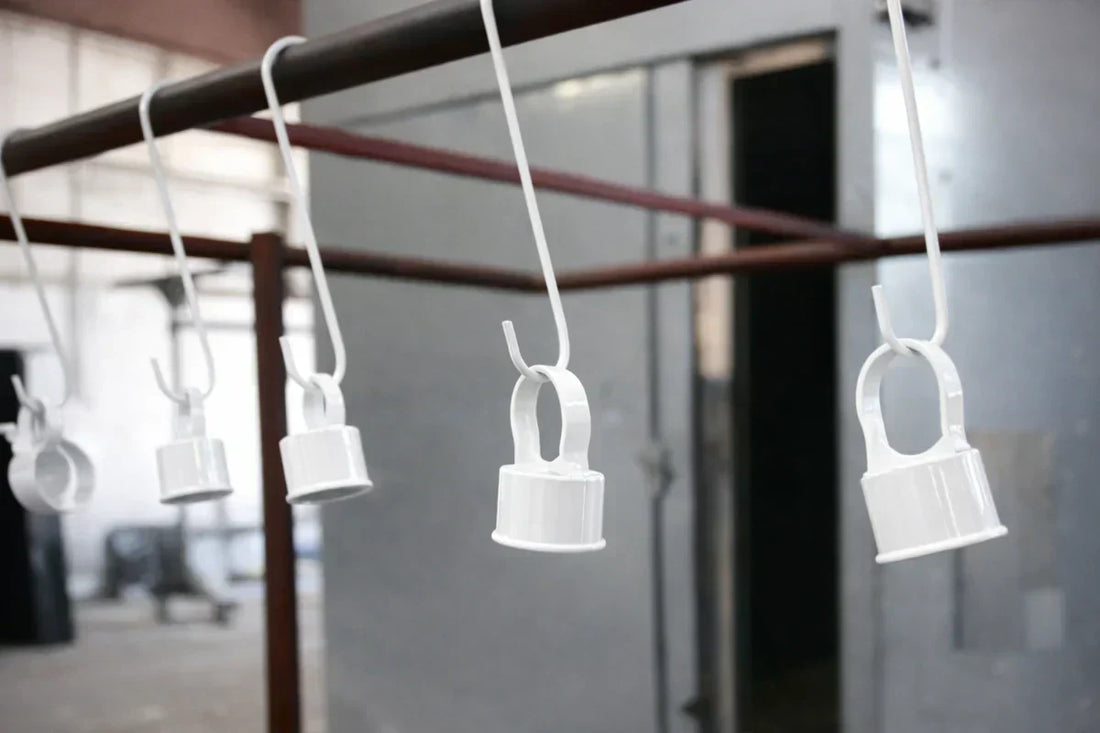 White powder coated parts hanging on powder coating hooks in an industrial coating line