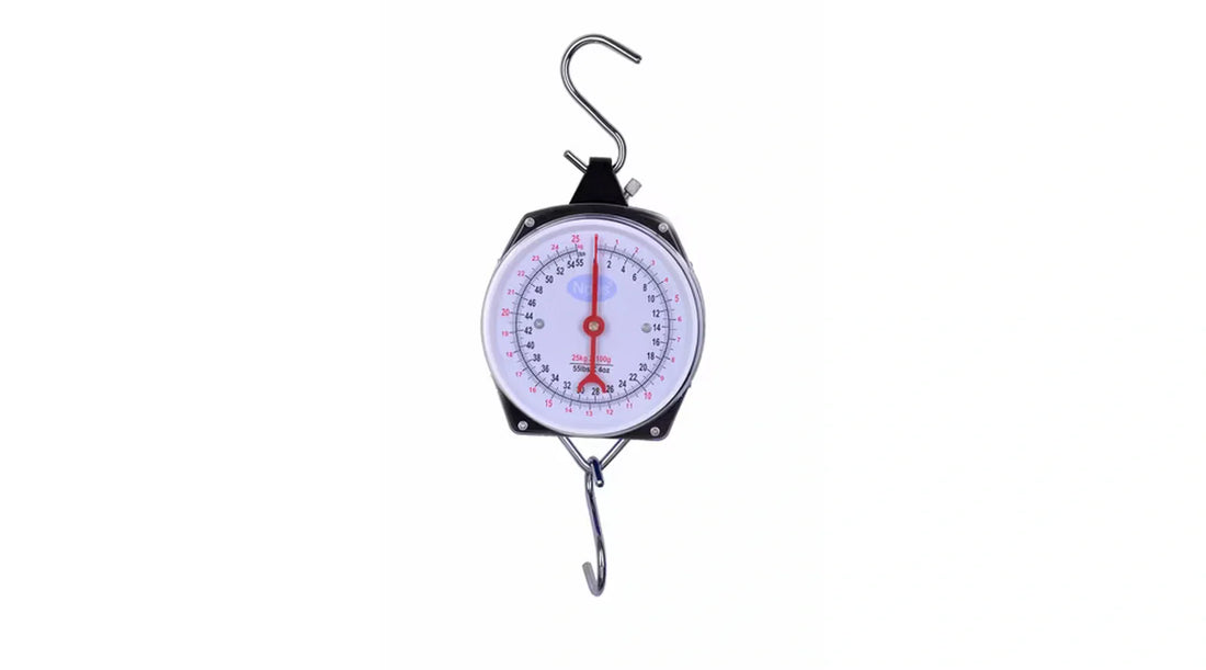 Hanging dial scale with a metal hook on a plain light background