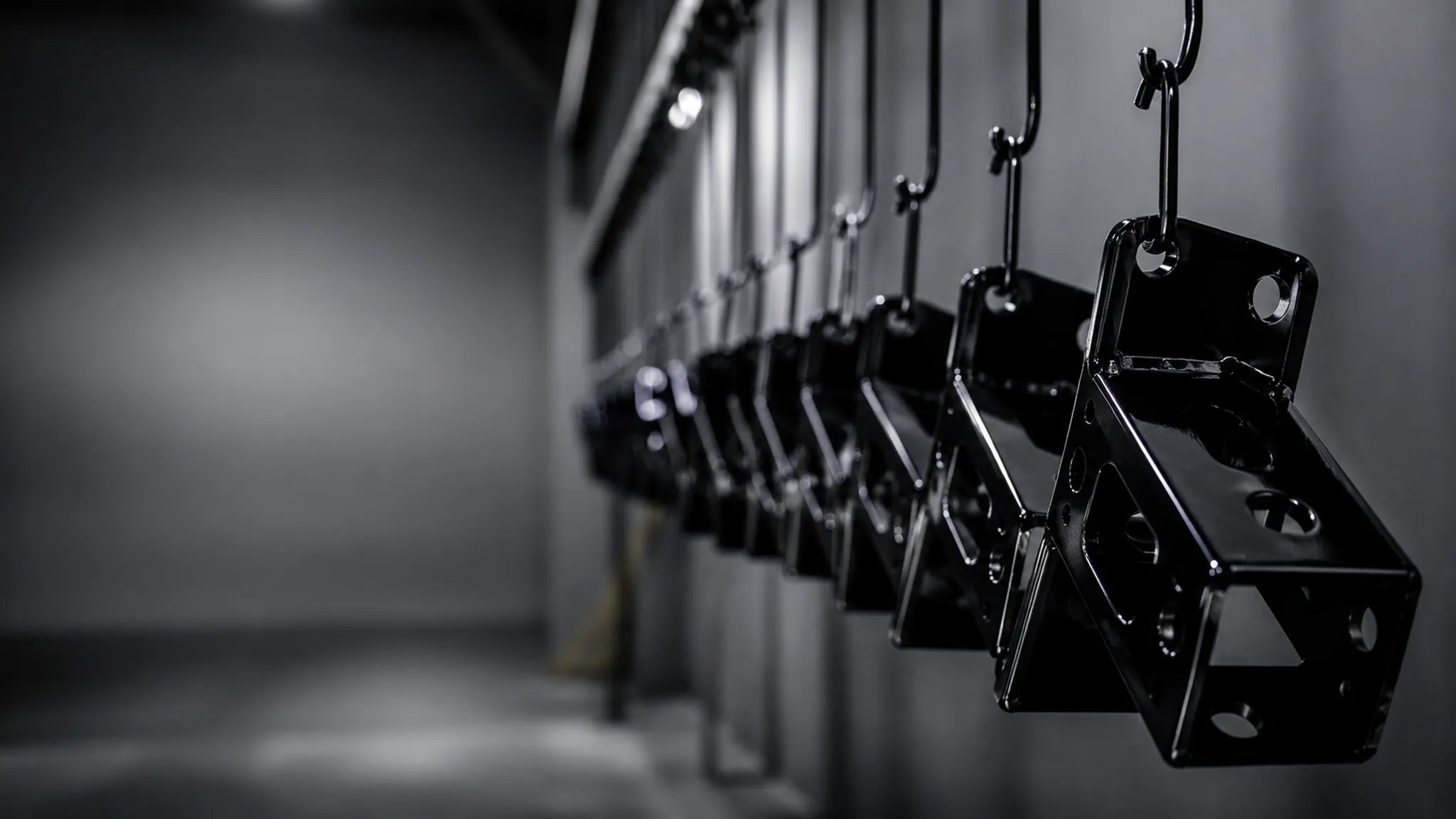 Powder coating line showcasing hooks holding a black coated part